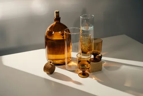 Pieces of clear and brown-stained glassware on the table with sunlight shining through them